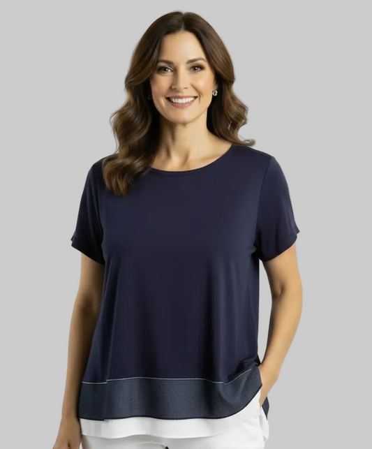 A woman modeling a navy blue short-sleeve top with a layered contrast hem